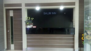 Ein Empfangsbereich mit einem Schild, auf dem 'SALIM INN' steht, und einer Blumenkomposition.