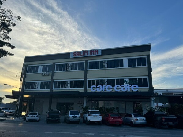 A building with a 'Salim Inn' sign at the top and a 'Care Care' sign below. There are several cars parked in front.