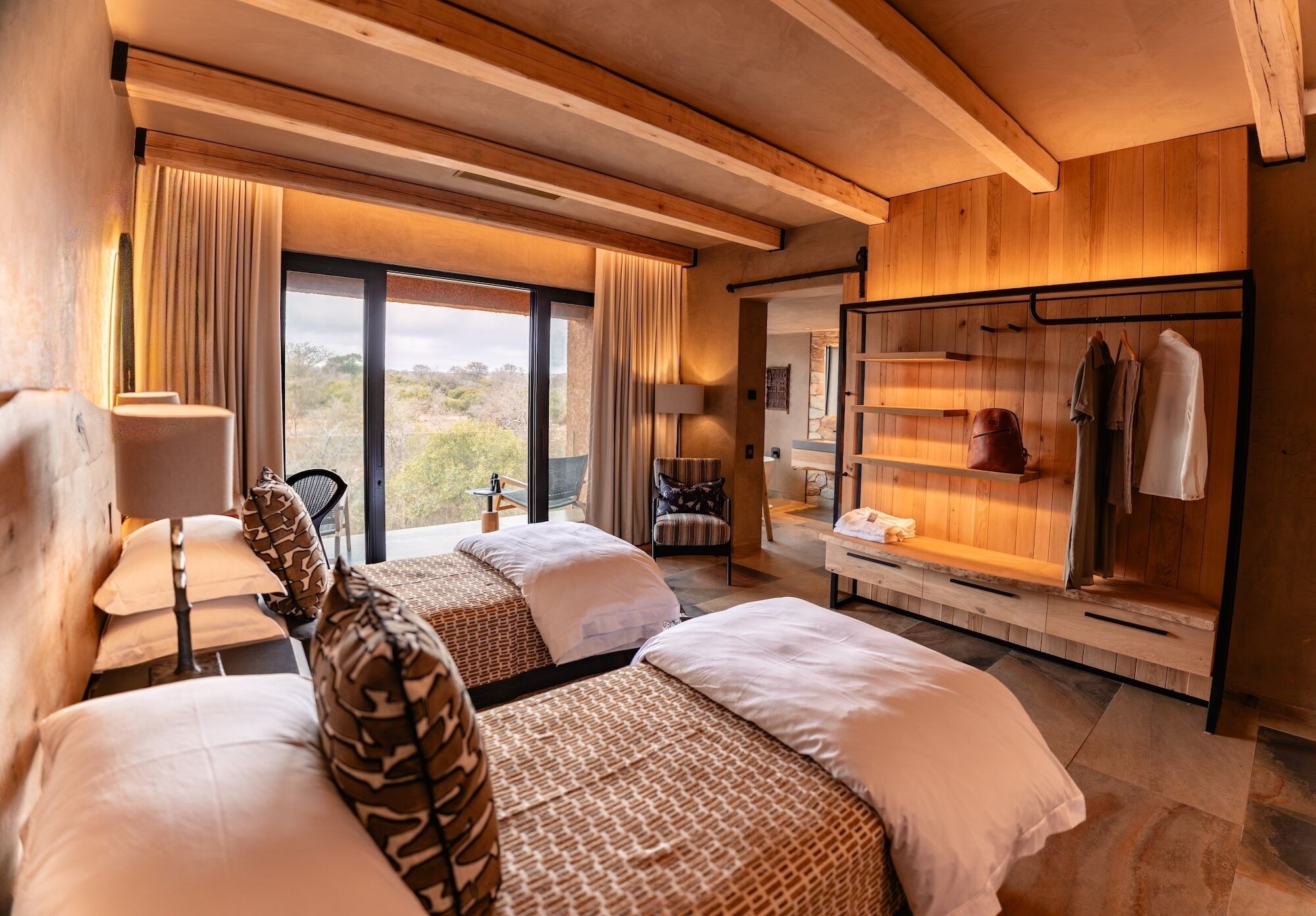 Een hotelkamer met twee bedden, een zithoek, een kledingkast en uitzicht op de omgeving.