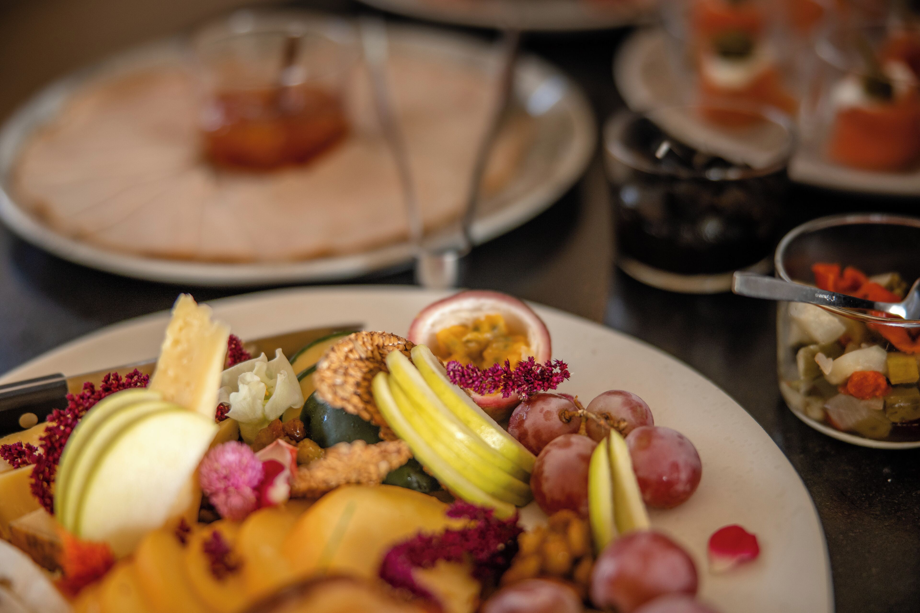 A table with a variety of fruits and nuts, including apples, grapes, and nuts, arranged on a plate.