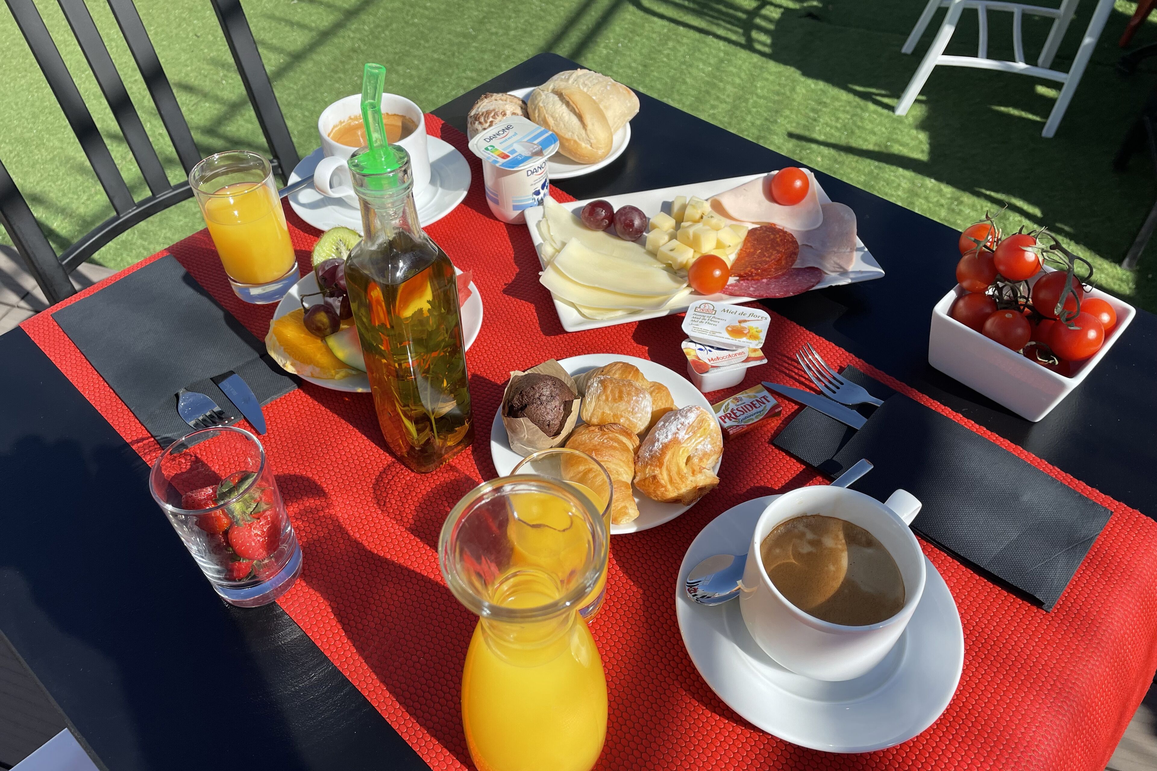 A table set with breakfast items including toast, eggs, cheese, tomatoes, and a drink.