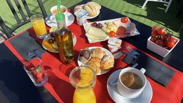 A table set with breakfast items including toast, eggs, cheese, tomatoes, and a drink.