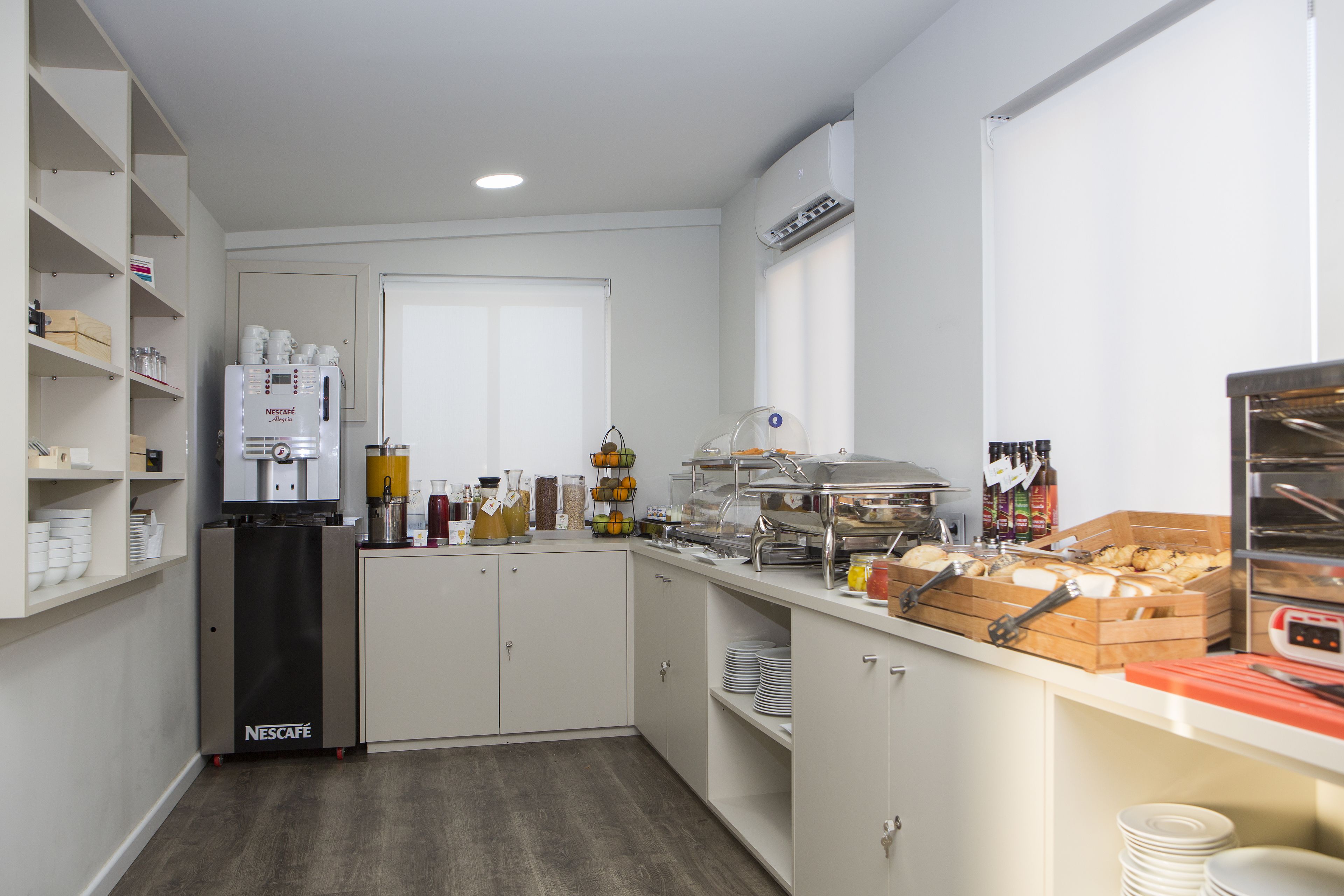 A modern kitchen with a Nescafé coffee machine, a food display, and a variety of kitchen appliances.