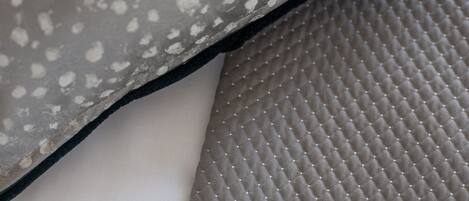 Een detail van een textiel met een patroon van kleine witte stippen en een zwarte rand.