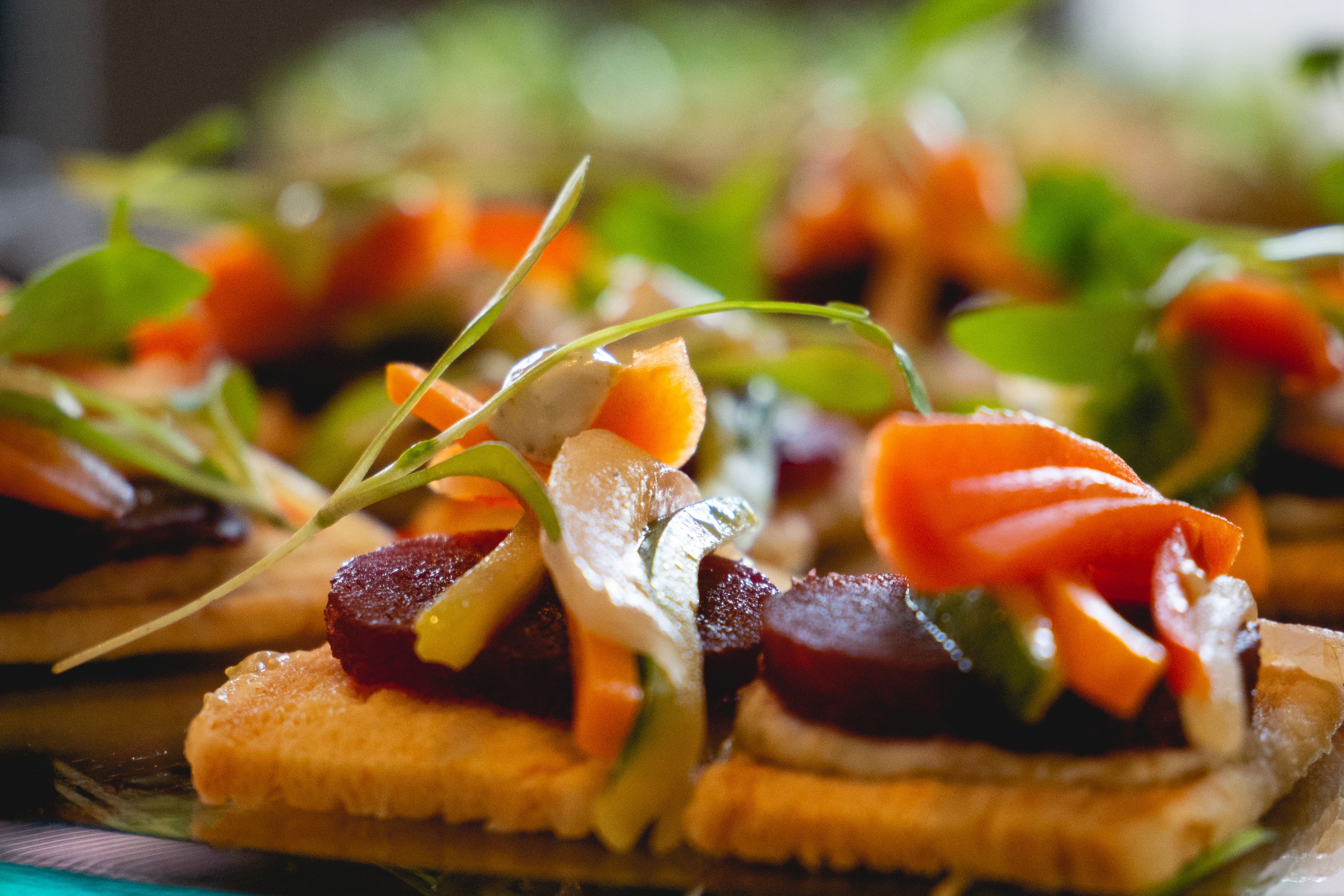 A close-up of a food arrangement with various vegetables and meats on a plate.