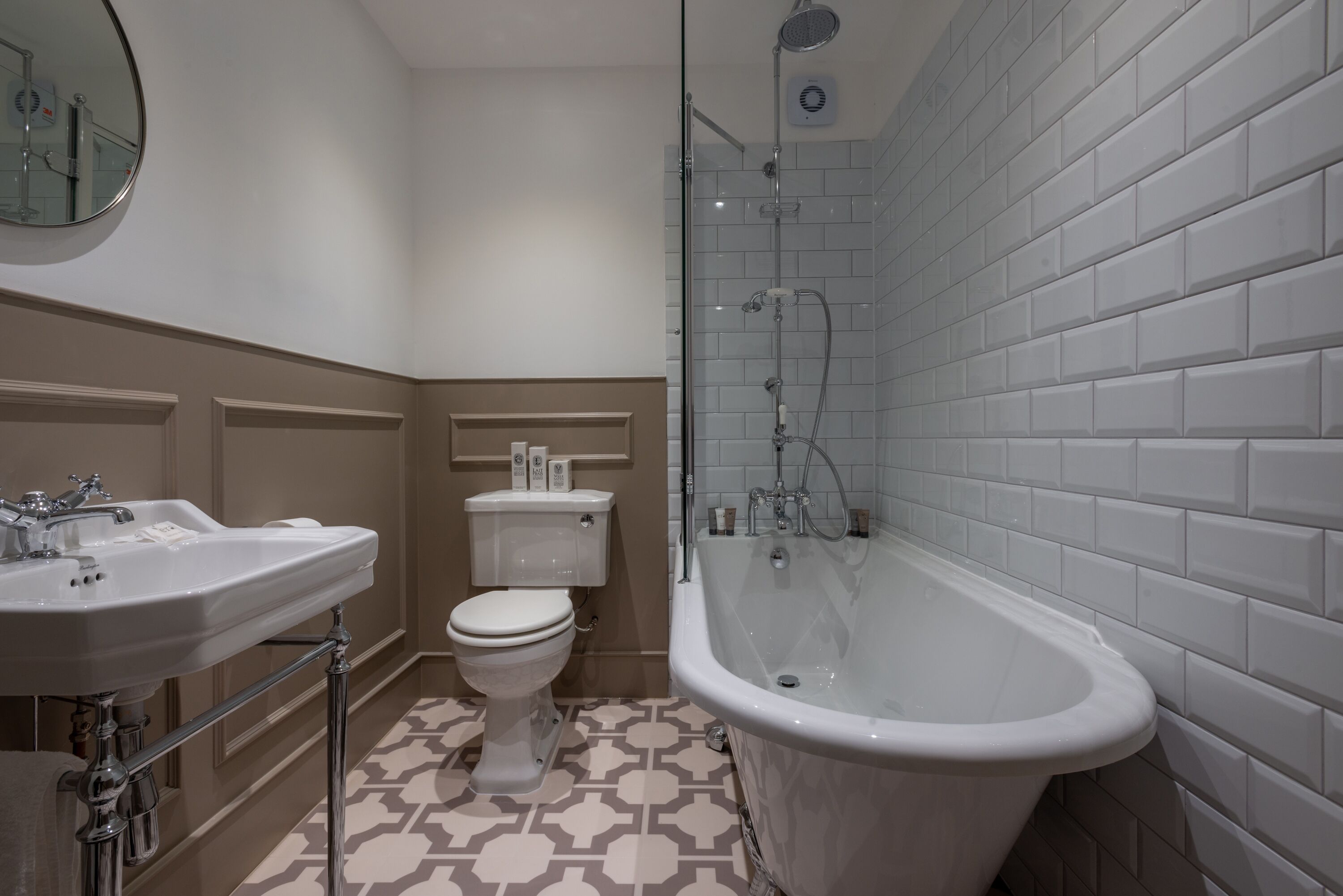 A bathroom with a bathtub, a toilet, and two sinks.