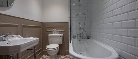 A bathroom with a bathtub, a toilet, and two sinks.