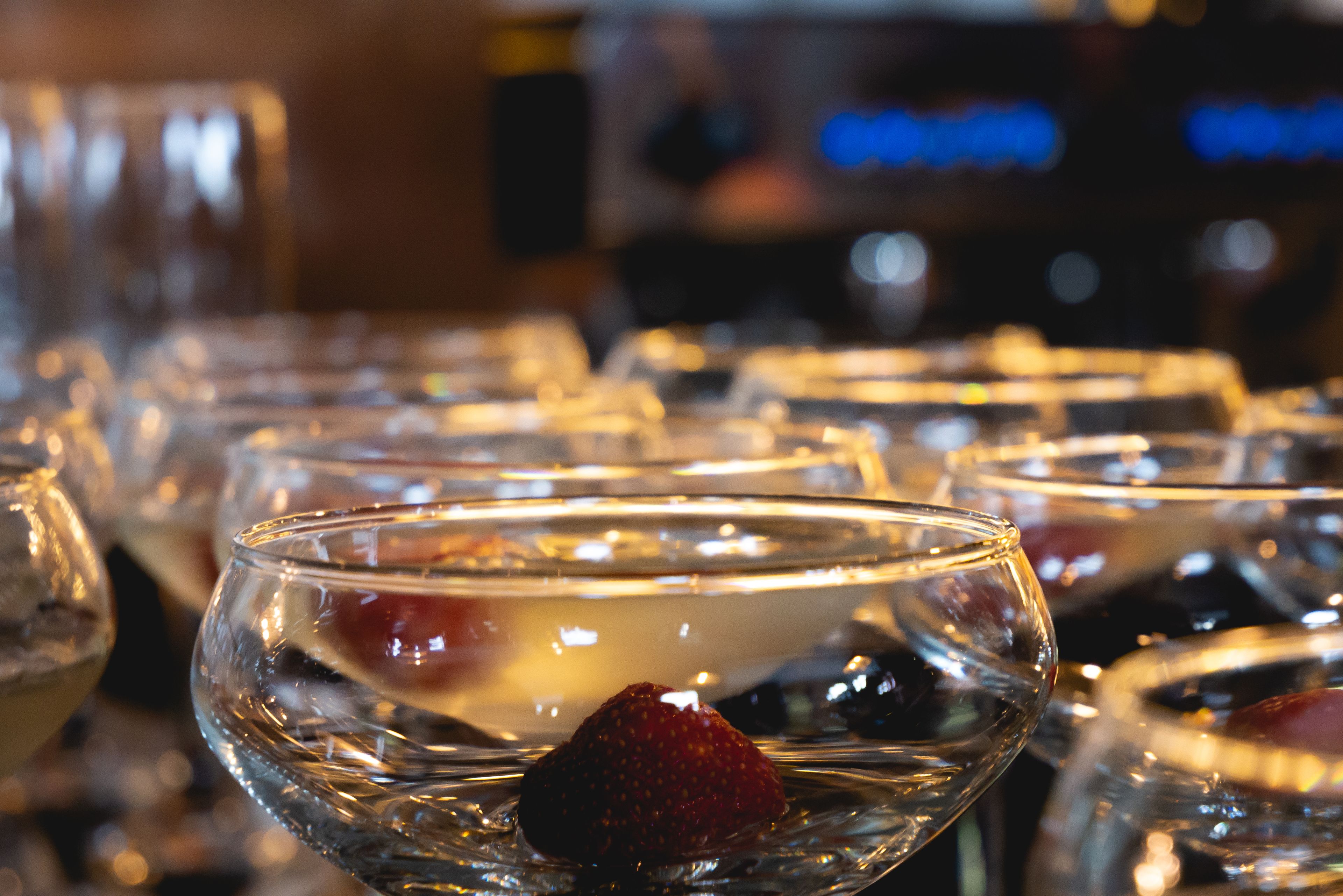 A bar setting with multiple glasses containing various beverages and garnishes.