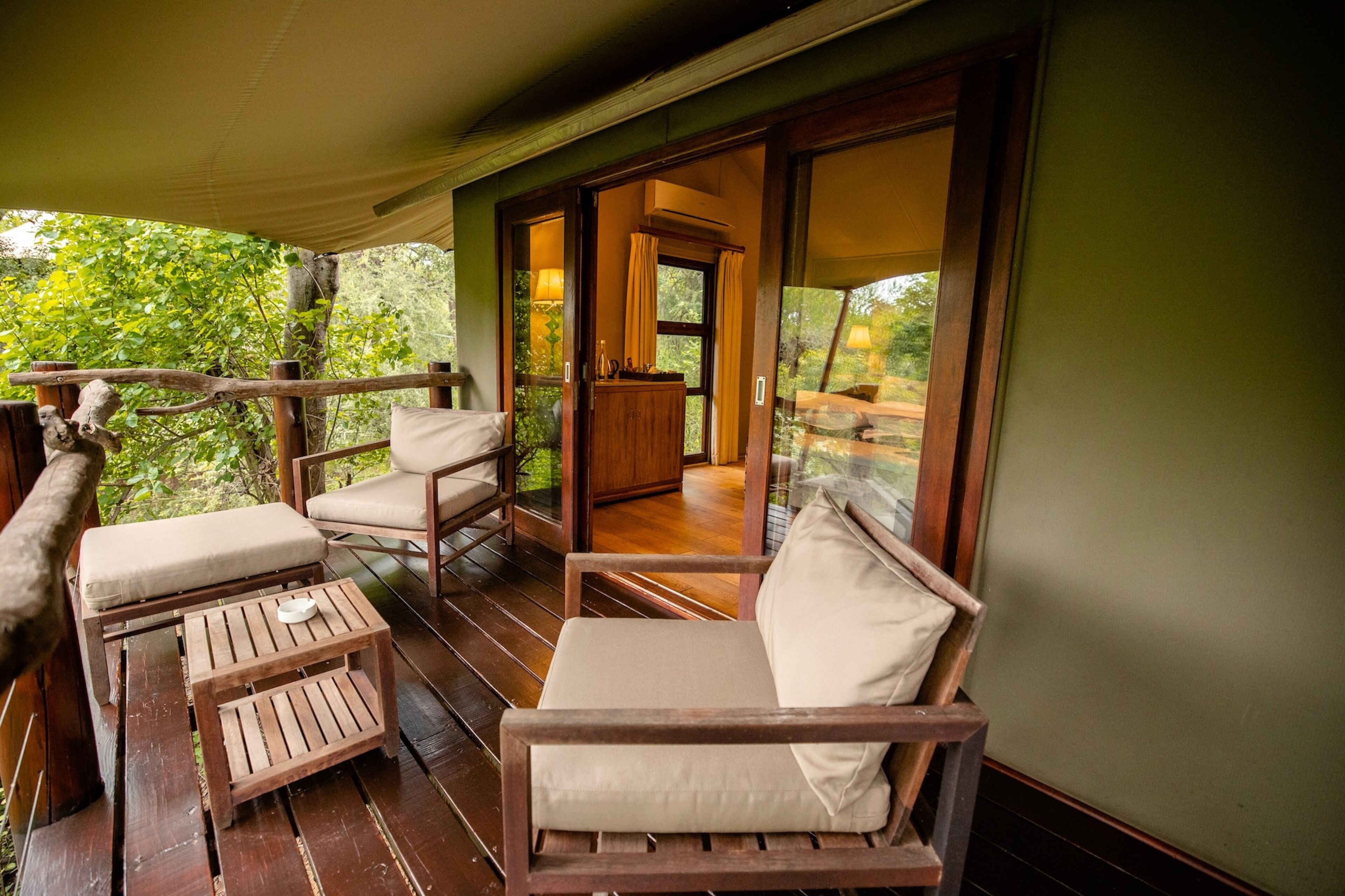 A wooden deck with a sofa, chairs, and a small table.