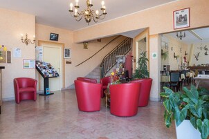 Un vestíbulo con asientos rojos, una escalera y un área de comedor.
