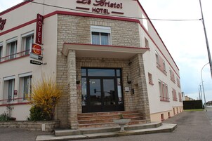 Un hotel con fachada de ladrillo, una entrada amplia y un letrero que indica que es un hotel de contacto.