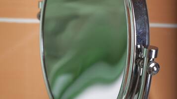 A round mirror with a metallic frame mounted on a wall.