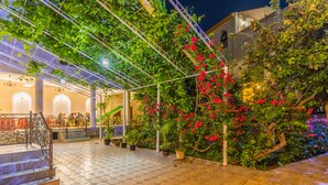 Un patio con piso de baldosas, una escalera y plantas en macetas.