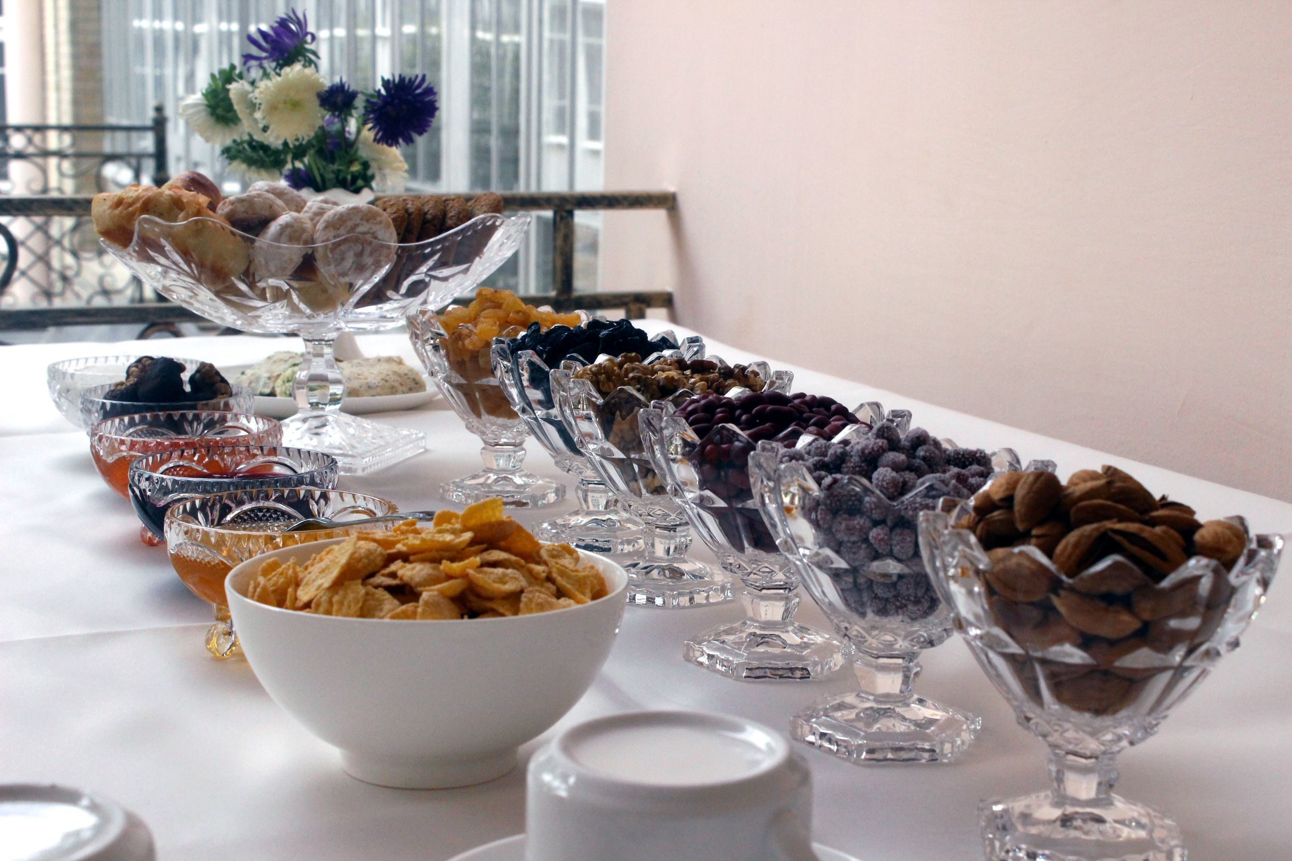 Una mesa de buffet con diversos alimentos y un bol blanco al frente.