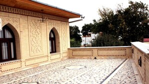 Un patio con baldosas estampadas y ventanas de arco.
