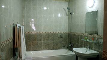 Ein Badezimmer mit Badewanne, Waschbecken und Spiegel.