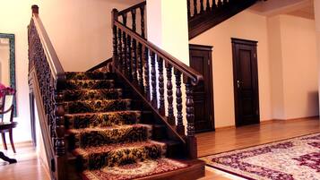 A staircase with ornate wooden balusters and carpeted steps.