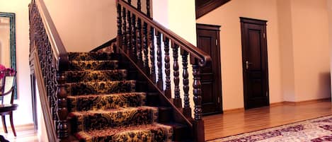 A staircase with ornate wooden balusters and carpeted steps.