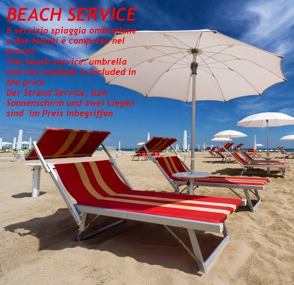 In Strandnähe, weißer Sandstrand, Liegestühle, Sonnenschirme