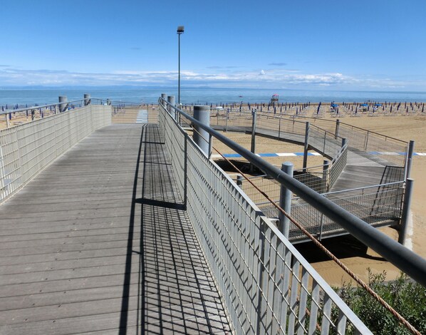 In Strandnähe, weißer Sandstrand, Liegestühle, Sonnenschirme