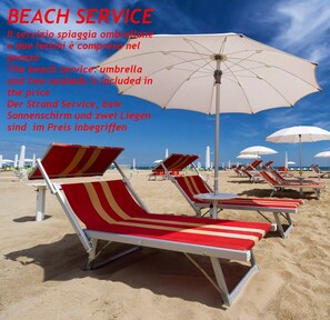 Vlak bij het strand, wit zand, ligstoelen, parasols