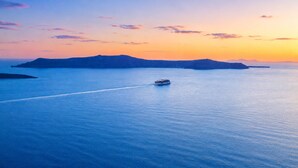 A cruise ship on a calm sea with distant landforms. - Santorini Heights (Santorini)