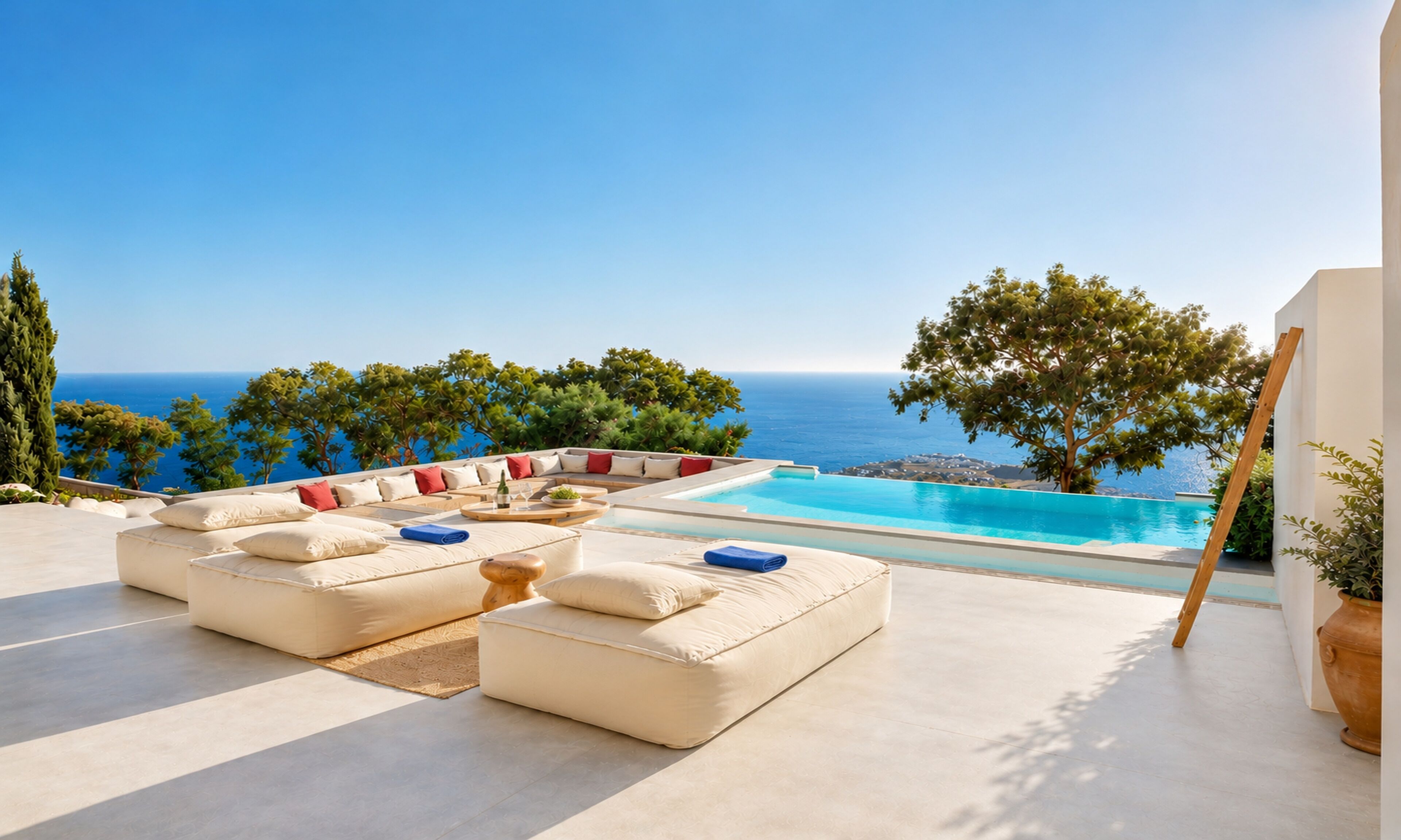 A poolside area with a sofa set and a view of the sea.