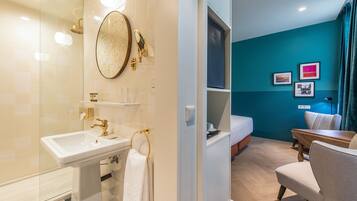 Un baño moderno con lavabo, espejo y ducha.