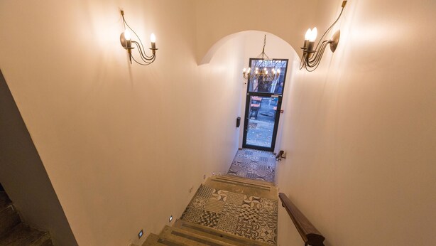 A staircase with patterned carpet leading to a door with a glass panel. - Kaplan Hotel Jerusalem (Jerusalem)