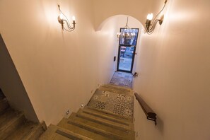 A staircase with patterned carpet leading to a door with a glass panel. - Kaplan Hotel Jerusalem (Jerusalem)