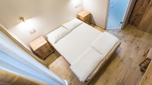 A bedroom with a large bed, wooden nightstands, and a wardrobe. - Kaplan Hotel Jerusalem (Jerusalem)