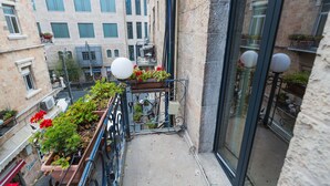 A narrow balcony with potted plants and a view of adjacent buildings. - Kaplan Hotel Jerusalem (Jerusalem)