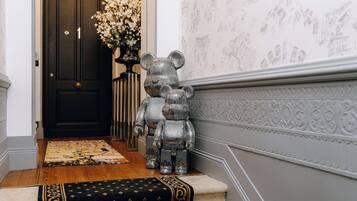 Una escalera con un tapete estampado, una escultura decorativa de un oso y una puerta con un número.