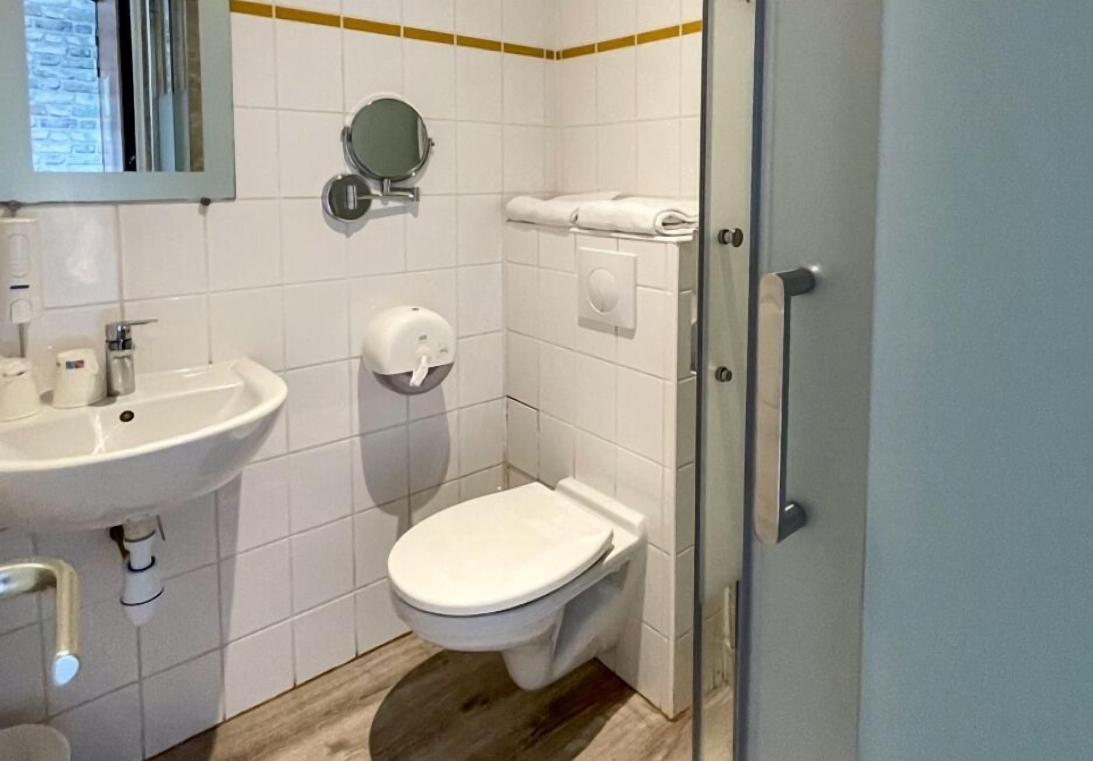 Un baño pequeño con lavamanos, inodoro y espejo.