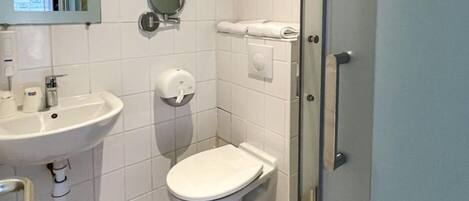 Un baño pequeño con lavamanos, inodoro y espejo.