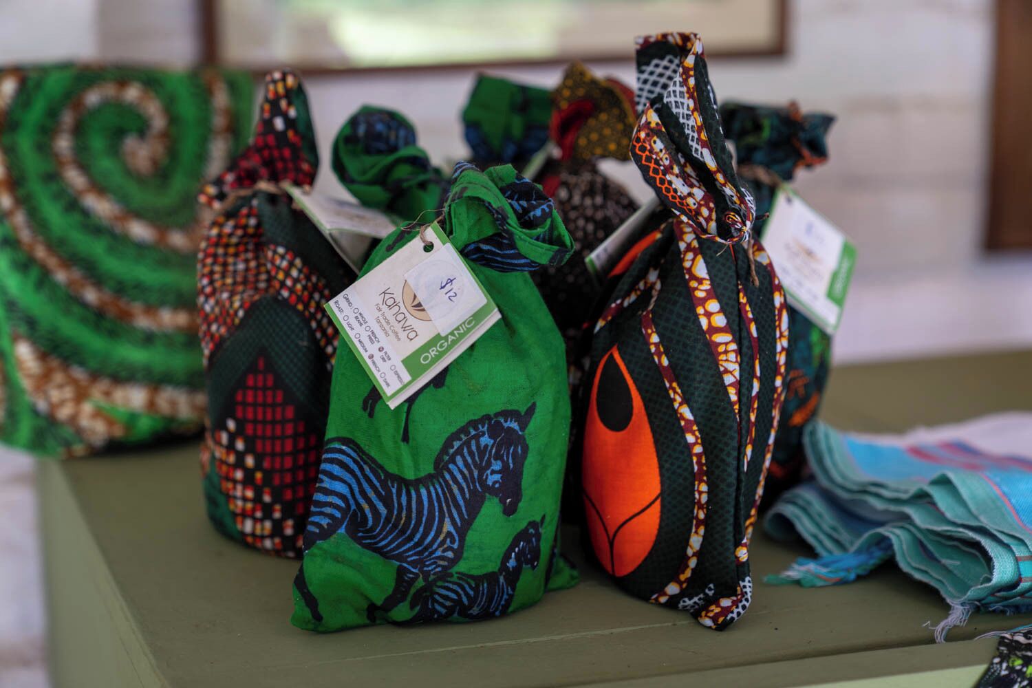 A table with several bags of organic fabric, each with a tag.