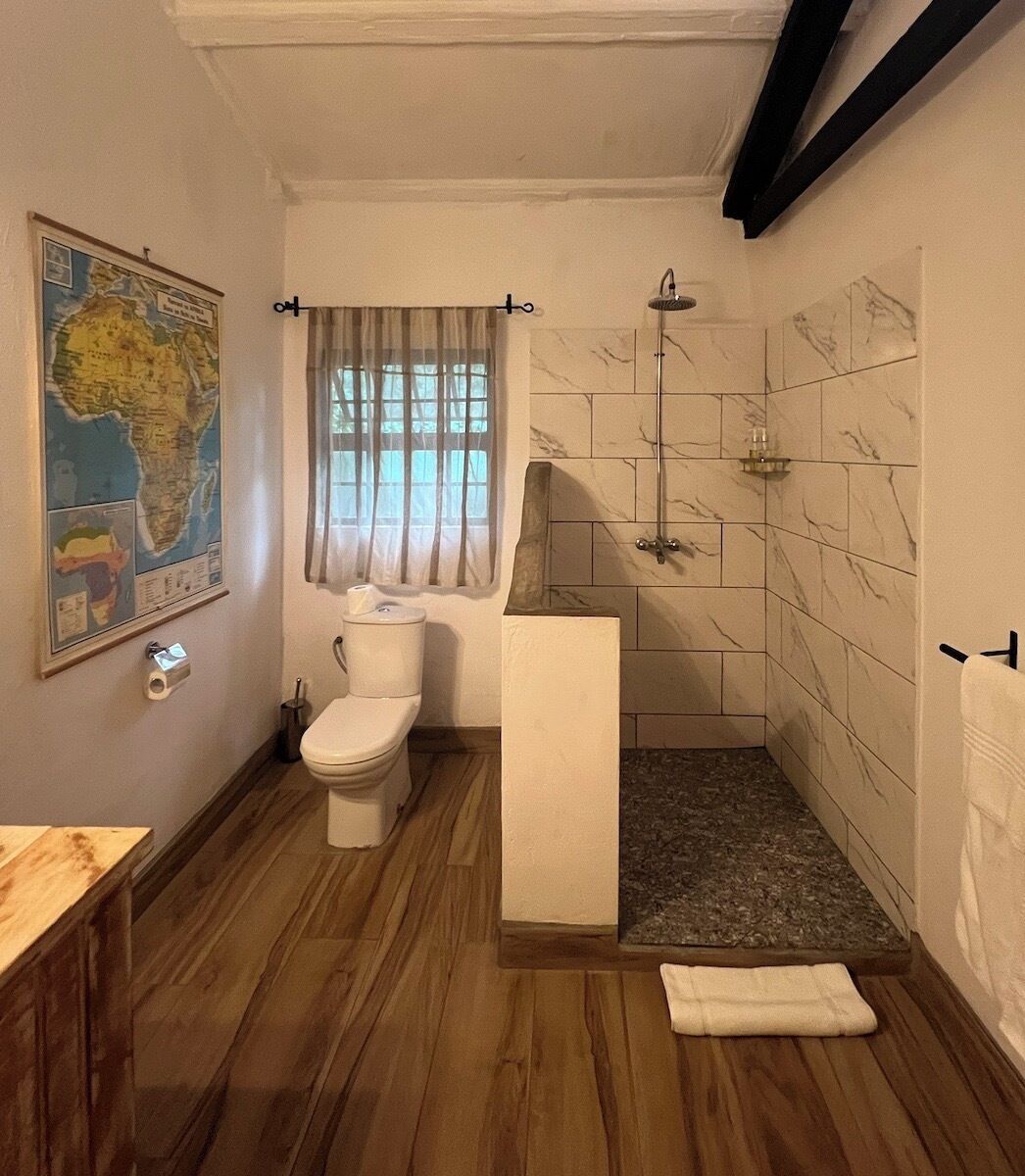 A bathroom with a toilet, shower, and a map on the wall.