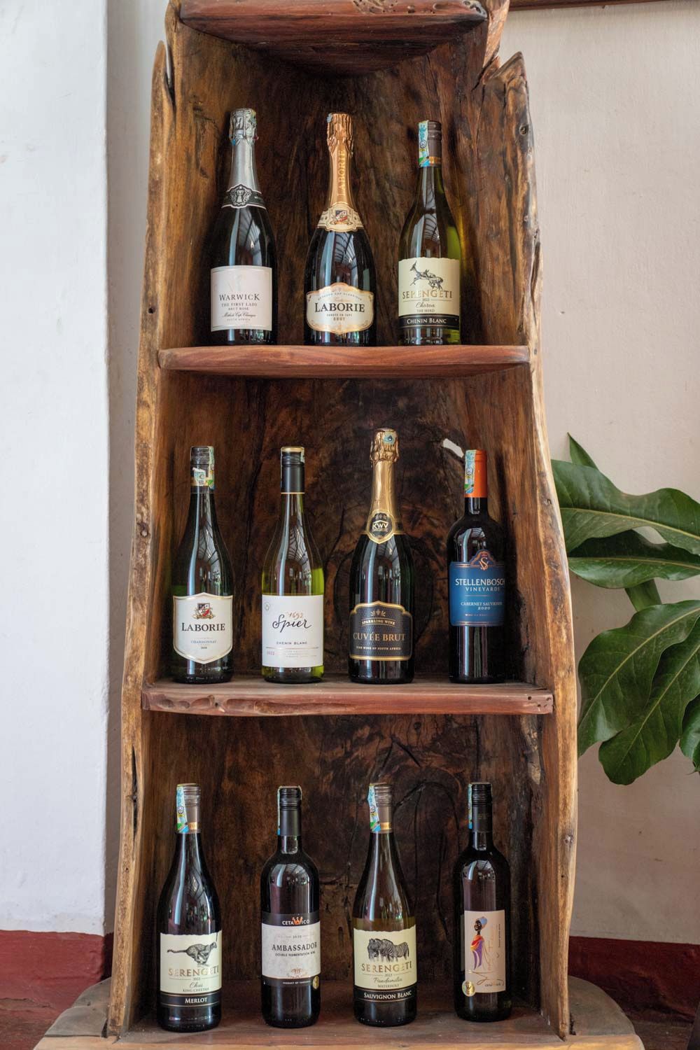 A wooden wine rack with various bottles of wine.