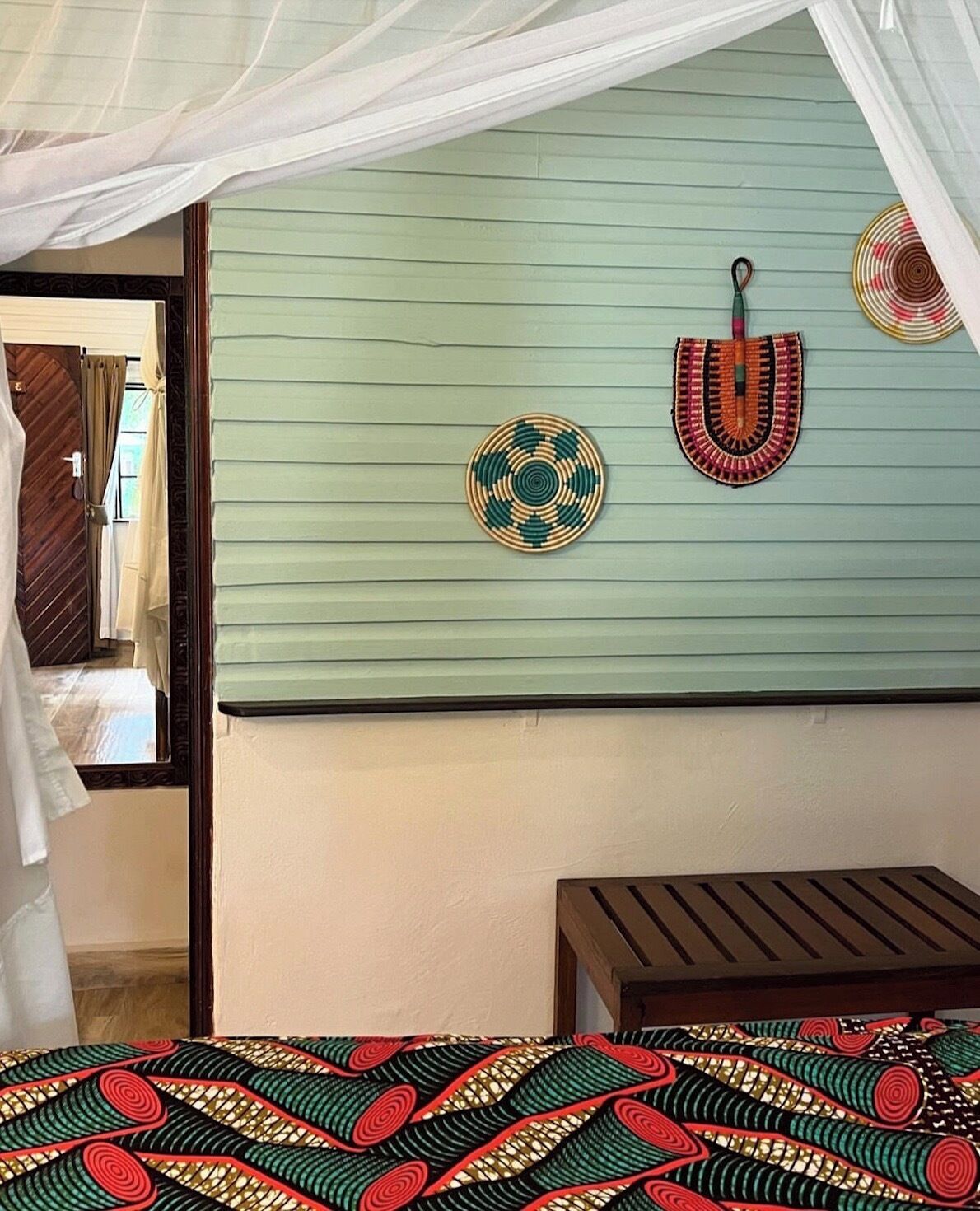 Ein Zimmer mit einem Bett, einem kleinen Tisch und einer Wand mit Dekorationen.