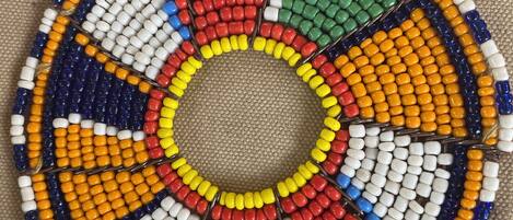 A circular beaded artwork with a central hole, featuring a variety of bead colors arranged in a radial pattern.