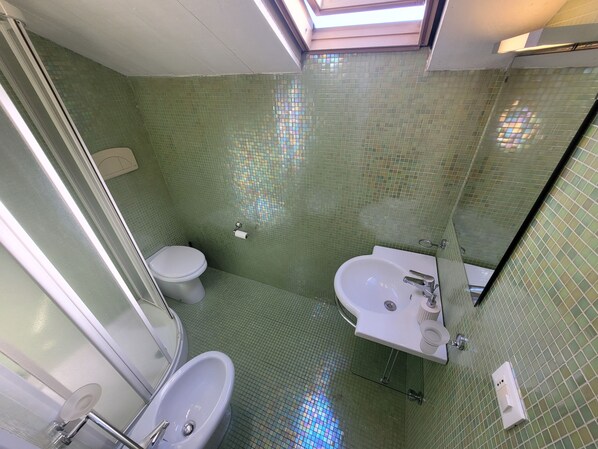 Ein Badezimmer mit Toilette, Waschbecken und Duschbereich.