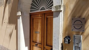 A wooden door with a metal handle, a mailbox, and a sign with the text "BB Le Terrazze Tropea".