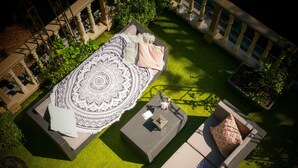 Un espacio al aire libre con un tapete estampado, dos sofás acolchados y una pequeña mesa.