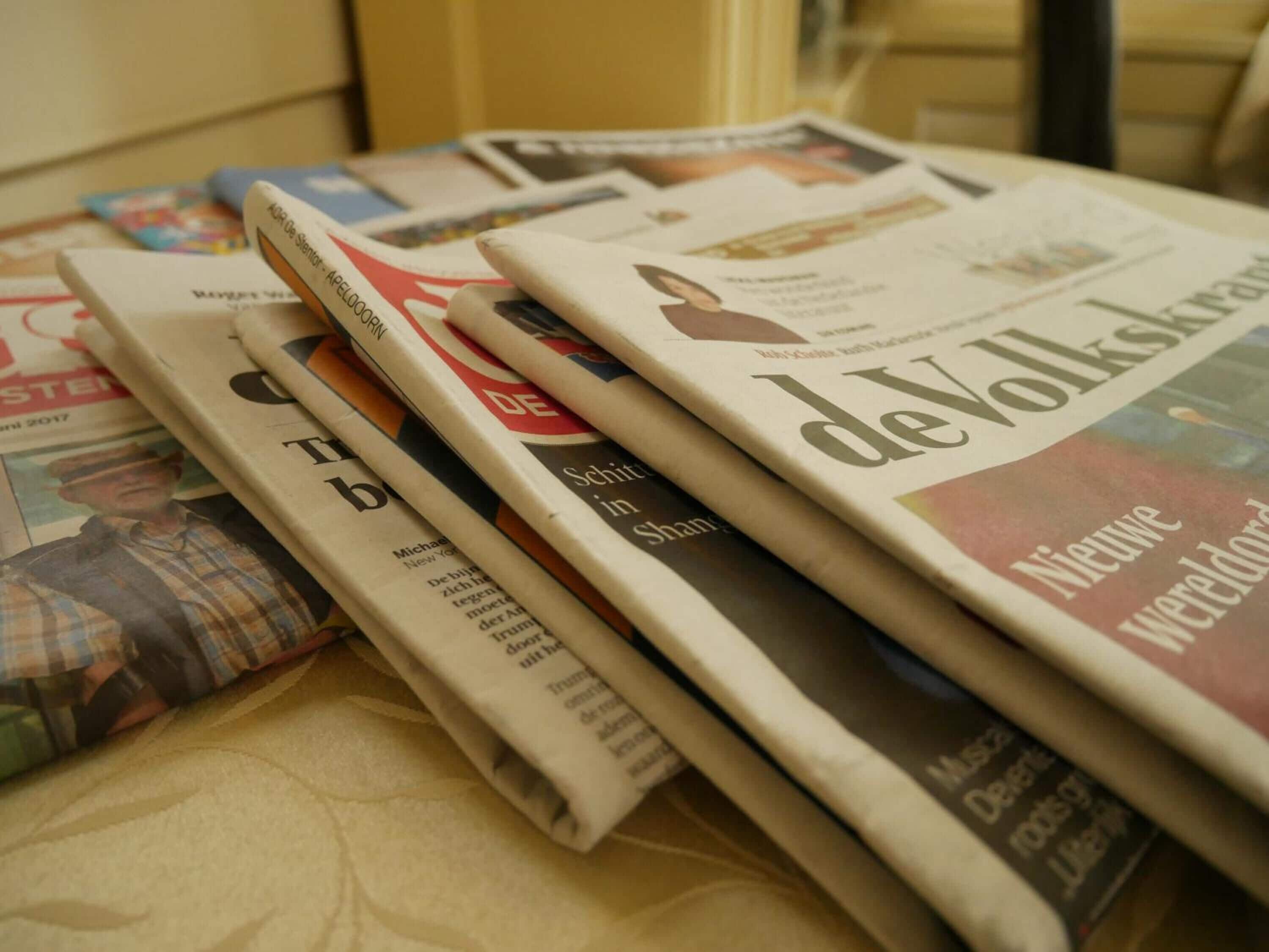 A stack of newspapers on a table.