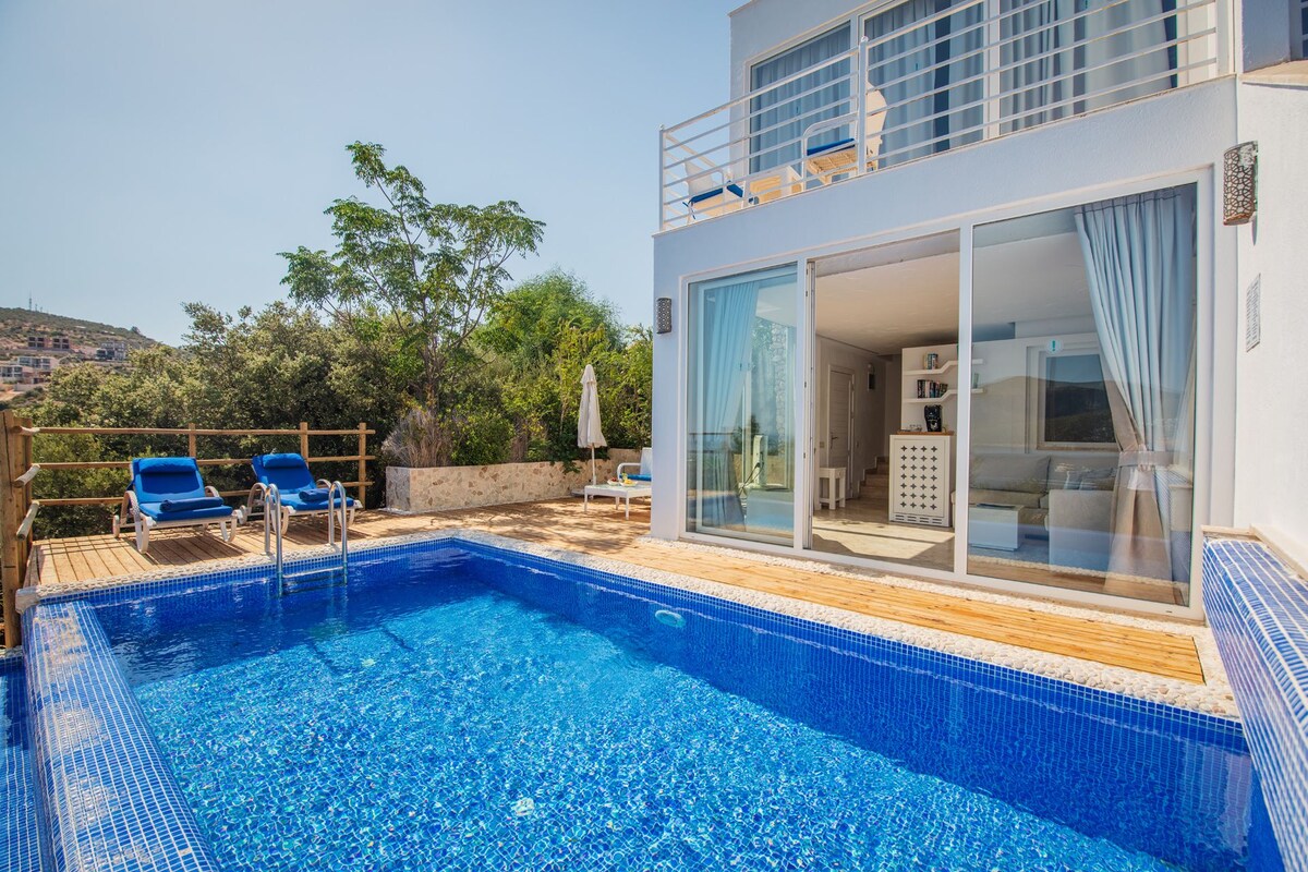 A modern villa with a swimming pool, a balcony with a view, and a well-maintained garden.
