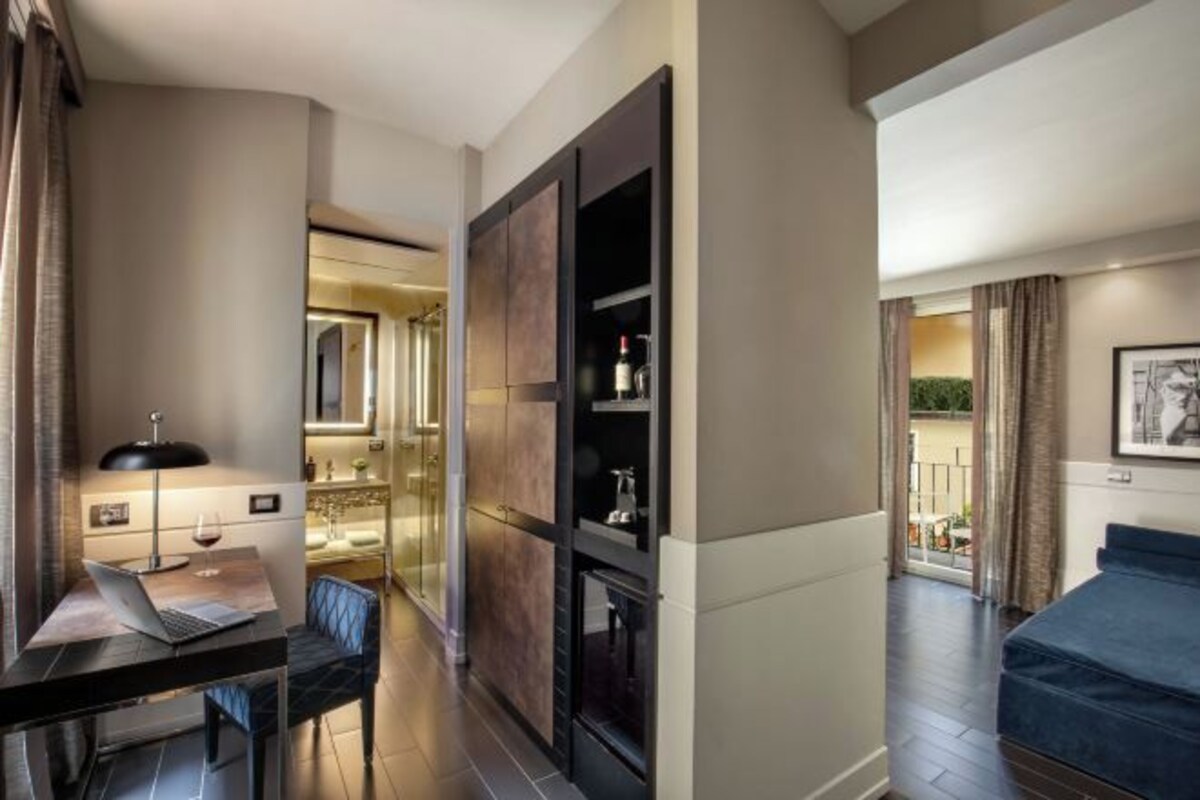 Une chambre d’hôtel moderne équipée d’un bureau, d’un ordinateur portable et d’un lit.