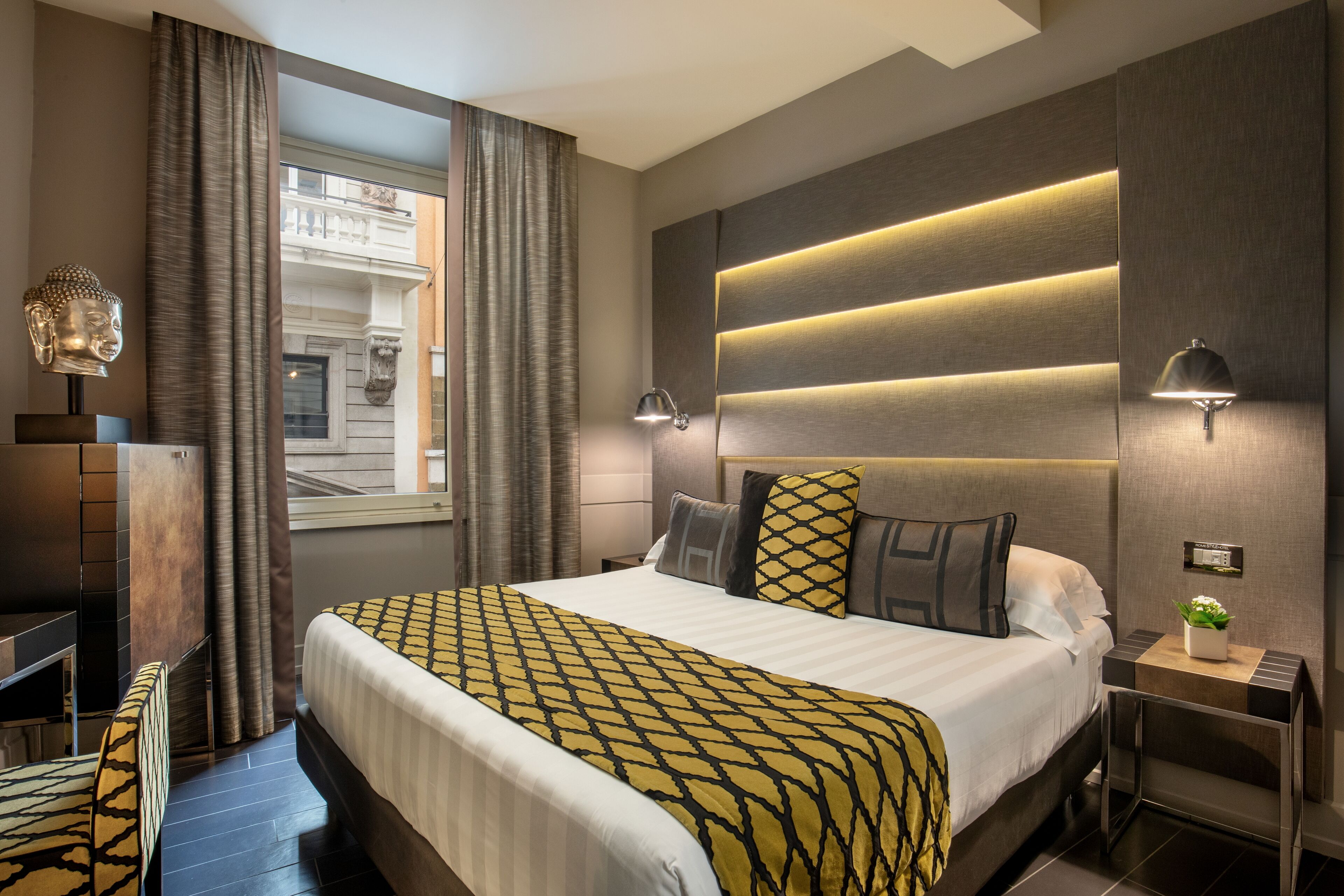 Ein modernes Hotelzimmer mit einem großen Bett, einem Schreibtisch und Blick auf ein Gebäude.
