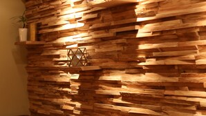 A wall with a textured, wooden panel design, a potted plant, and a poster. - Hotel FIVE (Nuremberg)