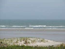 Una playa con dunas de arena y el océano.