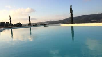 Seasonal outdoor pool, an infinity pool, pool umbrellas, pool loungers